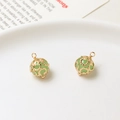 Detailed view of two vintage hollow flower copper pendants with light green crystal beads - 9*13mm / Pale Green