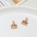 Close-up of golden crown pendants with micro-set zircons on a white ceramic plate - Crown Style (02#10*13mm)