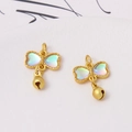 Detailed macro view of two golden butterfly charms with aurora heart wings and small bells - Iridescent Bowknot Style (LF2836)