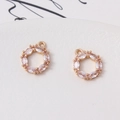 Makro-Detail von zwei Zirkonia-Kranzanhängern in Goldfassung für DIY-Schmuckherstellung - 13mm / Weiß
