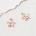 Macro detail of two pink zircon flower charms with gold bases for DIY jewelry making - 8*10mm / White