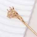 Macro view of gold flower hair pin featuring intricate petal textures and vintage style - Daffodil Style