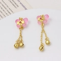 Golden butterfly earrings with pink wings and small bell pendants on a white tray - Pink