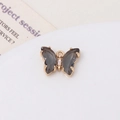 Détail d'un pendentif papillon doré avec des ailes gris fumé et des zircons scintillants - Gris