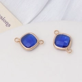 Gros plan de pendentifs en cristal bleu saphir avec cadre doré pour bijoux artisanaux - Bleu