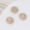 Macro detail of three daisy flower charms with sparkling zircons for jewelry making - White