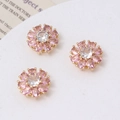 Detailed macro of pink daisy charms with sparkling zircon centers for DIY jewelry making - Pink