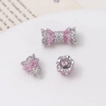 Macro shot of silver bow bead and crown spacers with pink drop zircon for jewelry DIY - Platinum Gold - Pink Zirconia