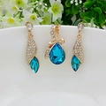 Elegantes goldenes Schmuckset mit blauen Kristallen, inklusive Ohrringen und einem Halskettenanhänger - Gold + Meerblau