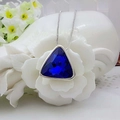 Macro view of a triangular navy blue crystal pendant with a sleek silver chain - Sapphire Blue