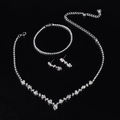Detail van een bruidssieradenset met sprankelende strassteentjes op zwarte achtergrond - Zilverkleurige Klauwketting Halsketting, Armband & Oorbellen Set (425+ Enkelrijige Armband)