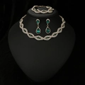 Detailweergave van een luxe sieradenset met smaragdgroene edelstenen en witte diamanten - Gouden Basis Groene Steen Ketting Armband En Oorbellen Combinatie