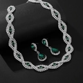Detailopname van verzilverde sieradenset met smaragdgroene stenen en witte strassteentjes - Zilveren Basis Groene Steen Ketting En Oorbellen Combinatie