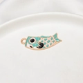 Detail eines minzgrünen japanischen Koinobori Emaille Anhängers auf weißer Keramik - 12*34mm / Hellblau