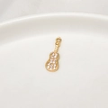 Dettaglio macro di un ciondolo a chitarra dorato con zirconi per creazioni di gioielli - Chitarra