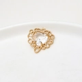 Macro shot of heart-shaped crystal pendant with gold hollowed-out lace border detail - White