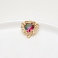 Macro view of a heart-shaped gradient faux tourmaline gemstone in gold lace setting - Green Pink Gradient