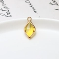 Macro view of a diamond-cut yellow gemstone pendant with a gold-plated copper border - Yellow