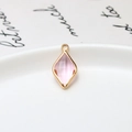 Macro detail of faceted pink waterdrop pendant with gold plated copper edging - Pink