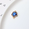 Détail macro d'un connecteur trèfle 12mm doré avec gemme bleue pour bijoux DIY - Connecteur Double Boucle Trèfle / Double Boucle Bleu