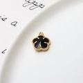 Vue macro d'un pendentif fleur à cinq pétales plaqué or 12mm avec centre noir - Noir