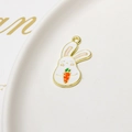 Detailed macro view of a cartoon rabbit alloy pendant with enamel carrot and gold trim - Holding Orange Carrot (06#)