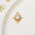 Close-up of golden teardrop pendant with central clear zircon stone on ceramic plate - No.04 / Teardrop (04#)