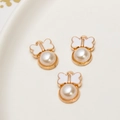 Close-up of alloy bow pendants with white enamel and imitation pearl for DIY jewelry - White