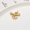 Macro shot of gold bow pendant with white cubic zirconia set on white ceramic plate - Bowknot Design Pendant (02#)