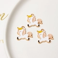 Detailed close-up of three enamel unicorn charms for DIY bracelets in gold-plated alloy - Pink