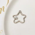 Detailed view of a silver star charm with rippled texture and an inlaid pearl - Silver Star Style