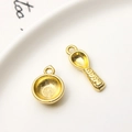 Macro shot of gold-plated bowl and spoon charms featuring Fú and BABY engraving - Bowl And Spoon
