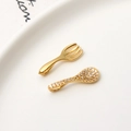 Macro detail of gold-plated miniature fork and spoon pendants with sparkling white zircons - Fork And Spoon