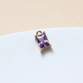 Macro shot of 6x10mm purple rectangle crystal pendant with gold-plated brass four-claw setting - Violet