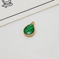 Macro detail of gold-plated geometric teardrop pendant with emerald green glitter inlay - Green