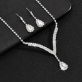 Detailed shot of pear-cut crystal necklace and earrings set on black texture surface - 630 (2-Piece Set) / Silver