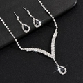 Detail van de zilveren ketting en zwarte druppelvormige oorbellen met ingelegde strasstenen - Zilver Zwart Ketting Oorbellen
