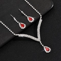 Detail van zilveren V-sieradenset met rode peervormige stenen en fonkelende kristallen - Zilver Rood Set