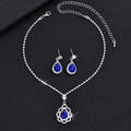 Detailed close-up of sapphire blue teardrop jewelry set with silver necklace and earrings - Blue