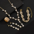 Makroansicht von Kristall-Strass-Schmuckset mit Kette und Ohrringen auf schwarzem Leder - 4-teiliges Set (Halskette+Ohrringe+Armband+Ring) / Gold