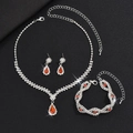 Makroaufnahme von Silberschmuck-Set mit roten Tropfensteinen und Kristallen auf Schwarz - Halskette Ohrringe Armband 3-teiliges Set / Silber Rot