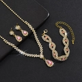 Nahaufnahme eines goldenen Brautschmuck-Sets mit funkelnden rosa Tropfenkristallen und Quasten - 3-teiliges Set (G229+746) / Gold-Rosa