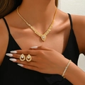 Nahaufnahme von Brautschmuck-Set mit Strass-Halskette, Ohrringen und Armband am Model - Wassertropfen Pavé Strass (G315) / Gold 3-Teiliges Set