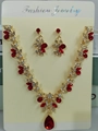 Detalle de conjunto de collar y pendientes de novia con cristales y gotas de agua rojas - Conjunto de joyas (G394) / Dorado-Rojo