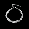 Detaillierte Makroansicht des gedrehten Silberarmbands mit Strasssteinen und Verschluss - Armband