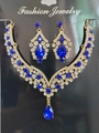 Detailed view of luxury bridal jewelry set with deep blue teardrop stones on black display - Gold Blue