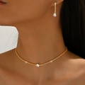 Elegant gold necklace and earring set with shimmering round zircon stones on model - Gold