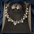 Golden butterfly jewelry set with pearls and rhinestones on blue velvet background - Gold White