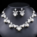 Silver butterfly jewelry set with rhinestones and white pearls on a black display stand - Silver
