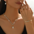 Elegant gold bridal jewelry set with sparkling drop pendants on a luxury model - Necklace Earrings Bracelet Ring Set (G0023) / Flower Bracelet And Ring Gold
